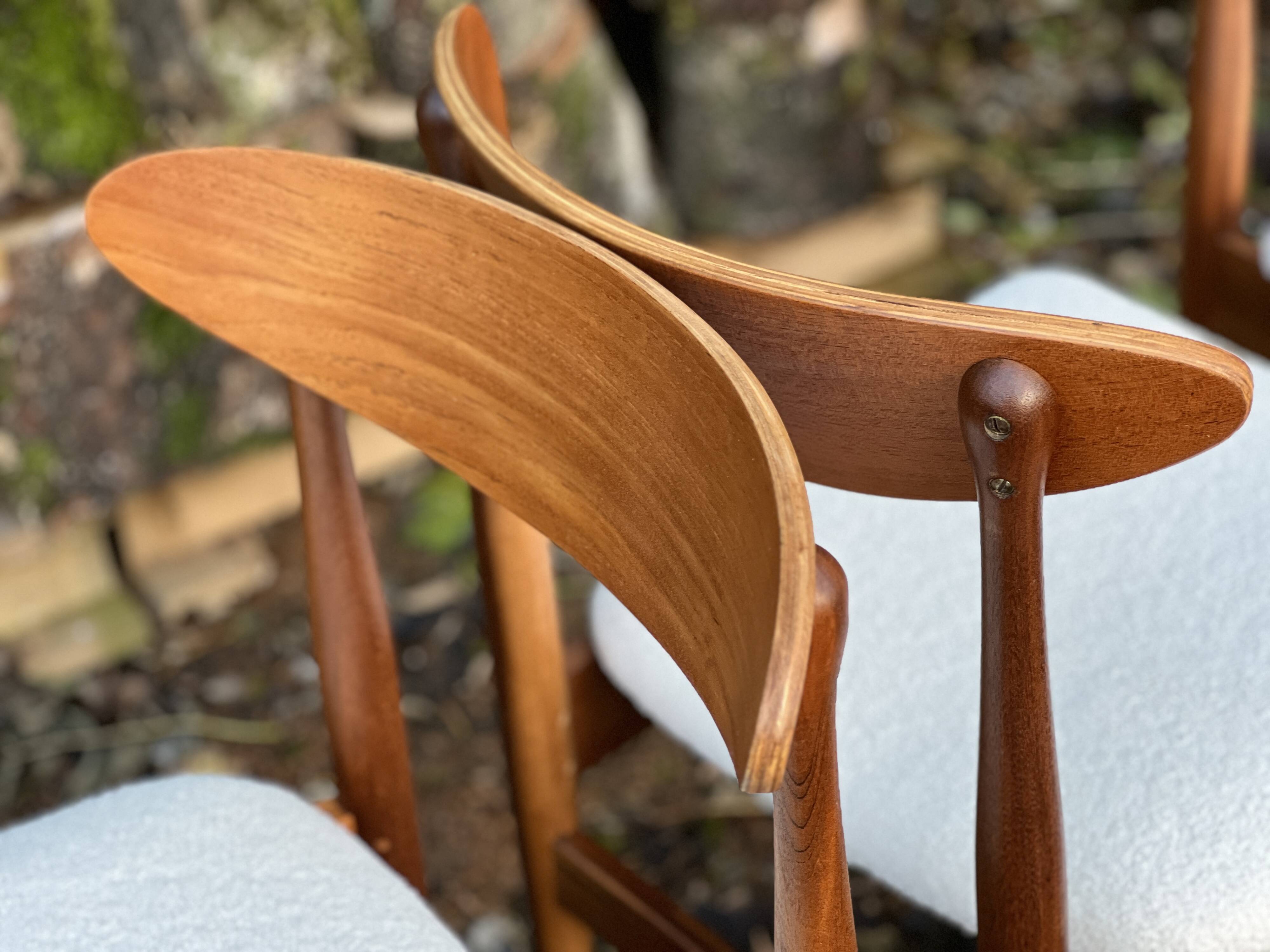 A set of GPlan chairs in teak with a white woolly fabric