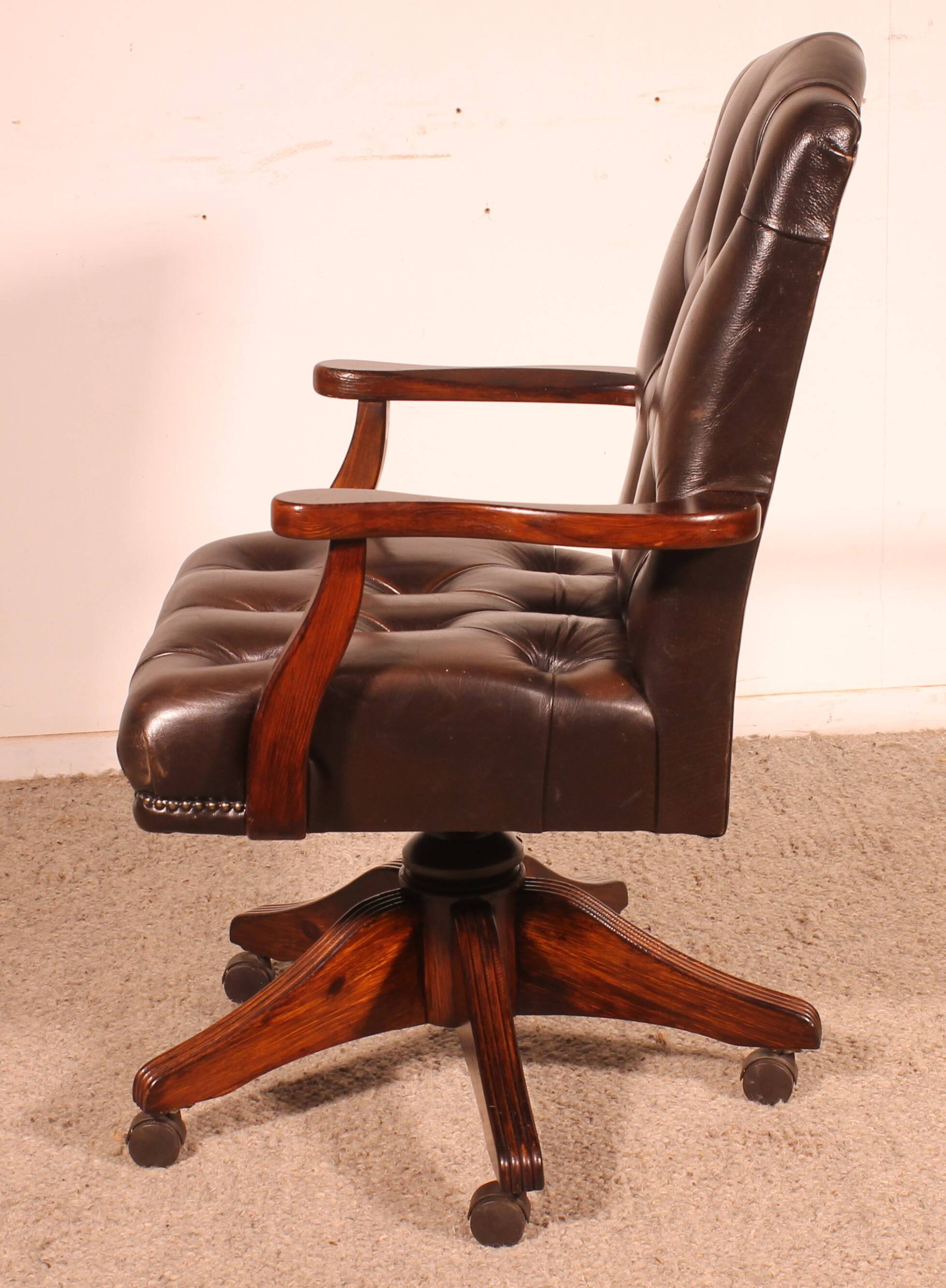 Office chair known as a director's chair in wood and tufted leather.