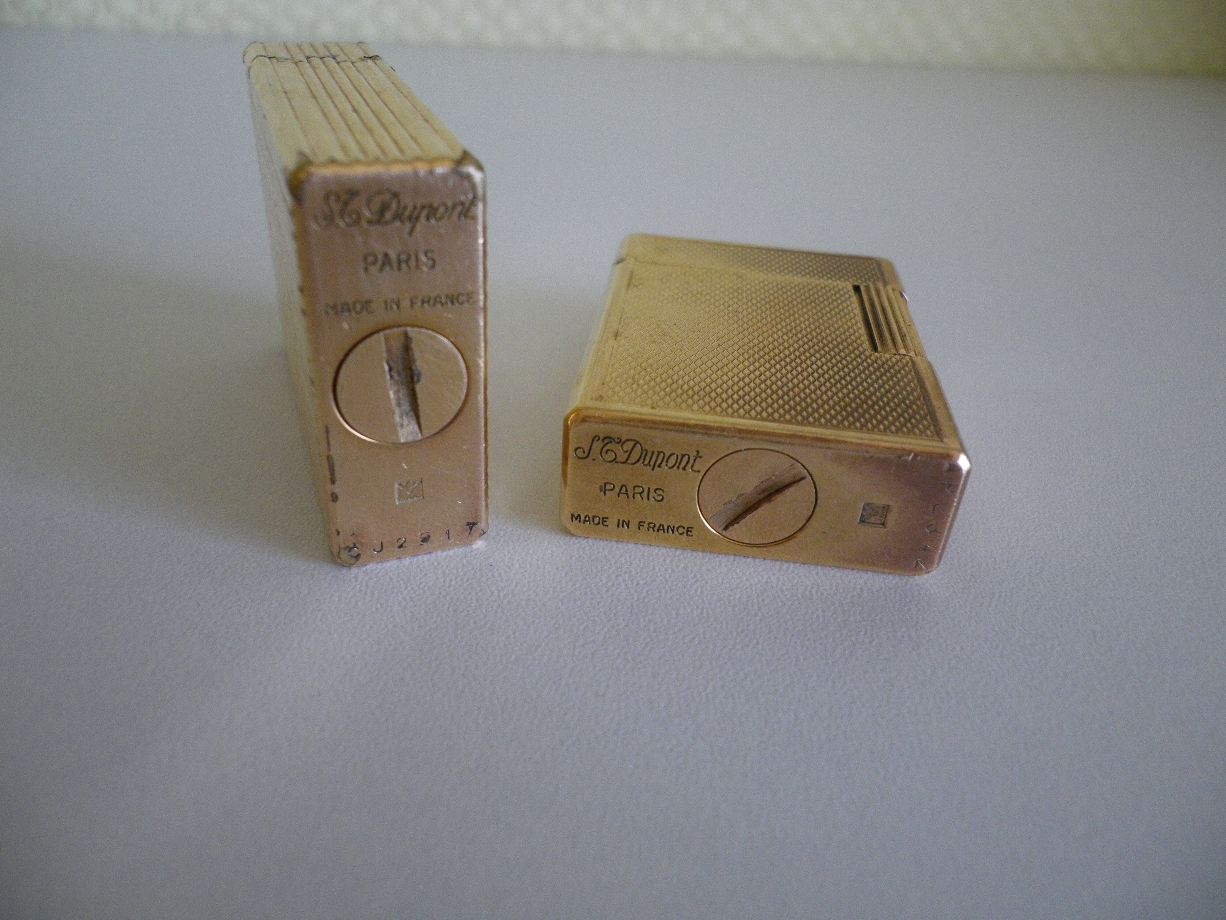 2 st dupont lighters, gold plated, punches, numbered, 1 striated pattern, 1 hammered pattern, 70s