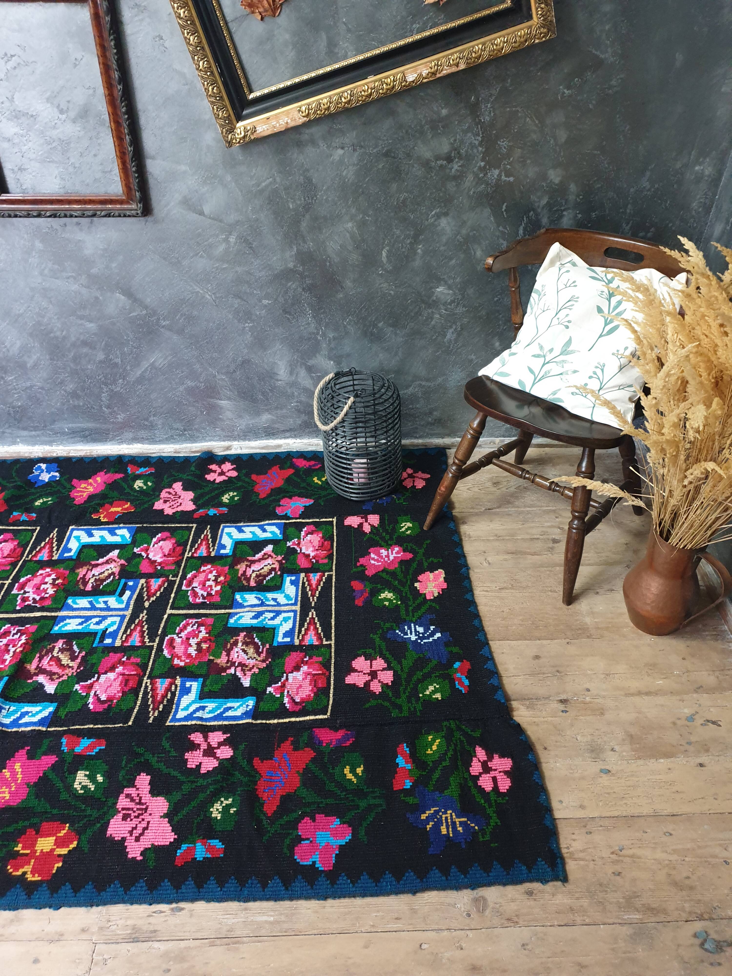 Handwoven floral wool rug, black background with pink roses and geometric design 207x144cm
