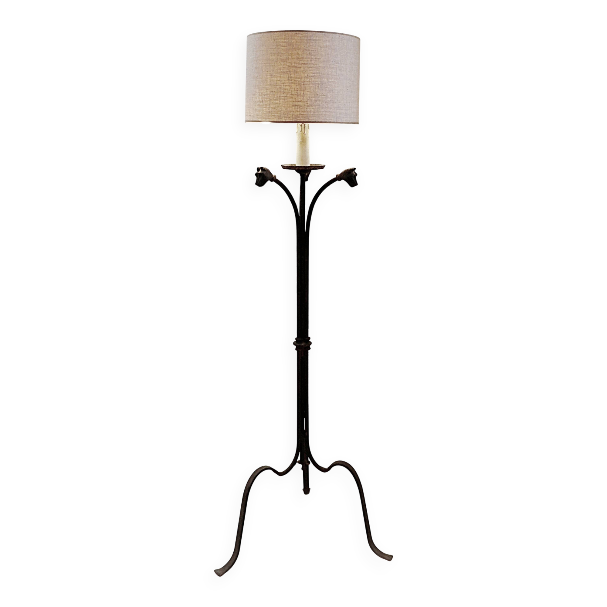 Wrought iron tripod floor lamp decorated with stylized animal heads