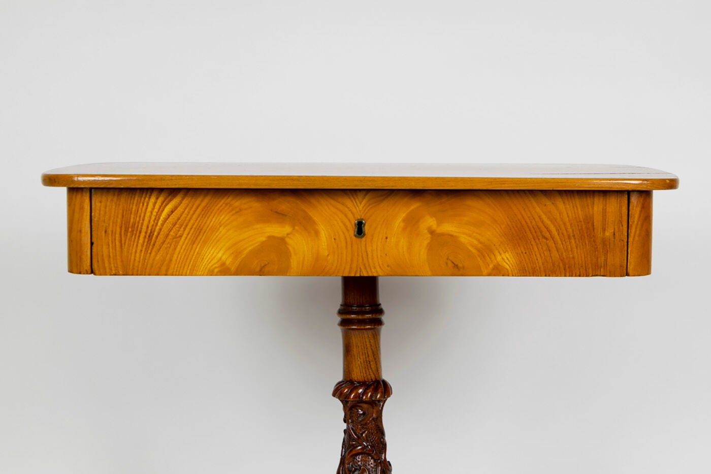 Danish Biedermeier elm occasional table with carved base and drawer