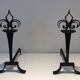 Important pair of wrought iron andirons with torch in heraldic fleur-de-lis design.