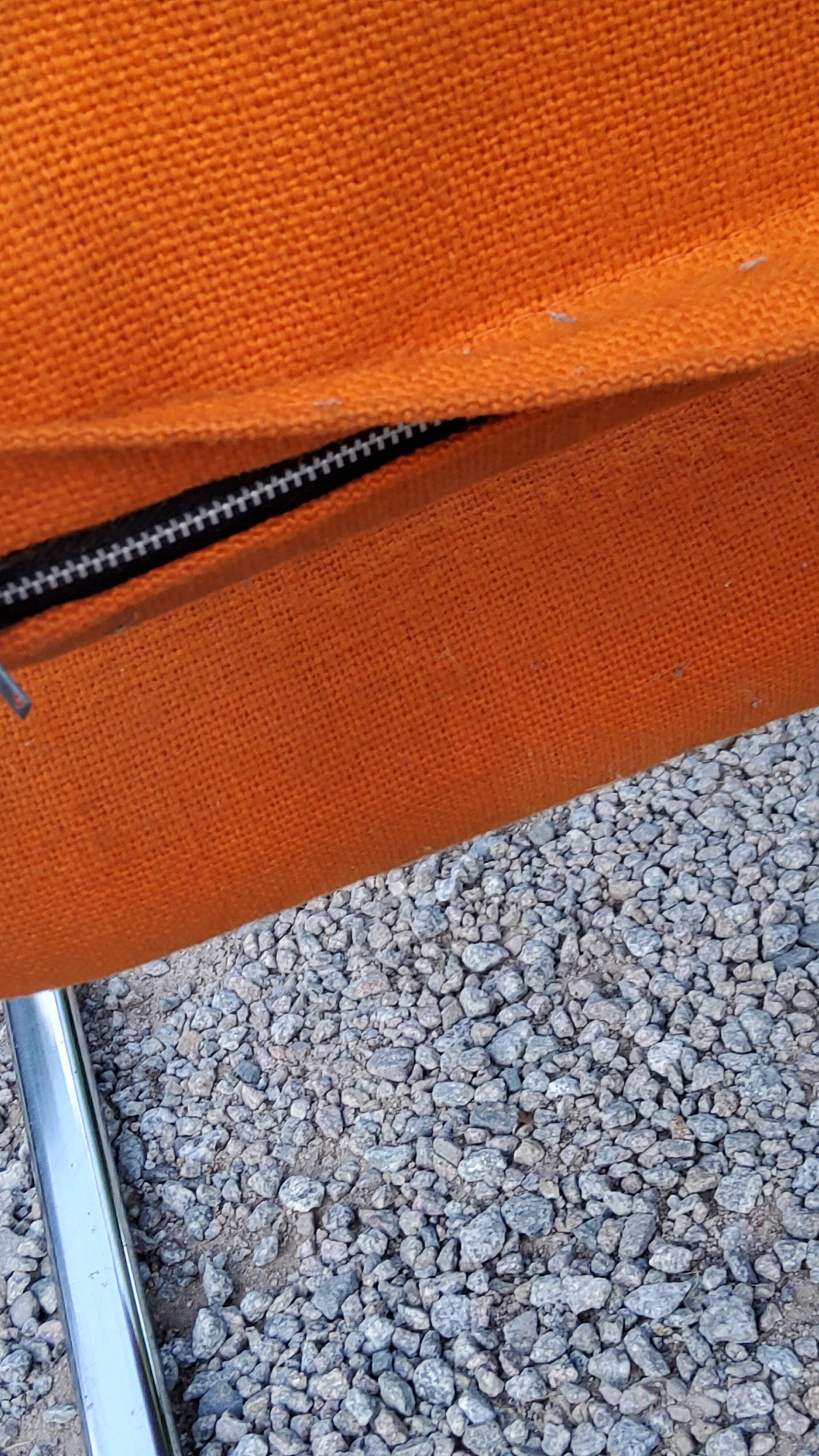 Pair of designer armchairs in orange fabrics and chrome tubes from the 70s