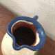 Terracotta jug with grape decoration.