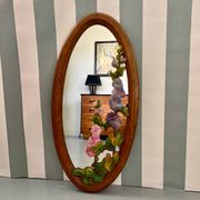 Carved wooden mirror with flower decorations.