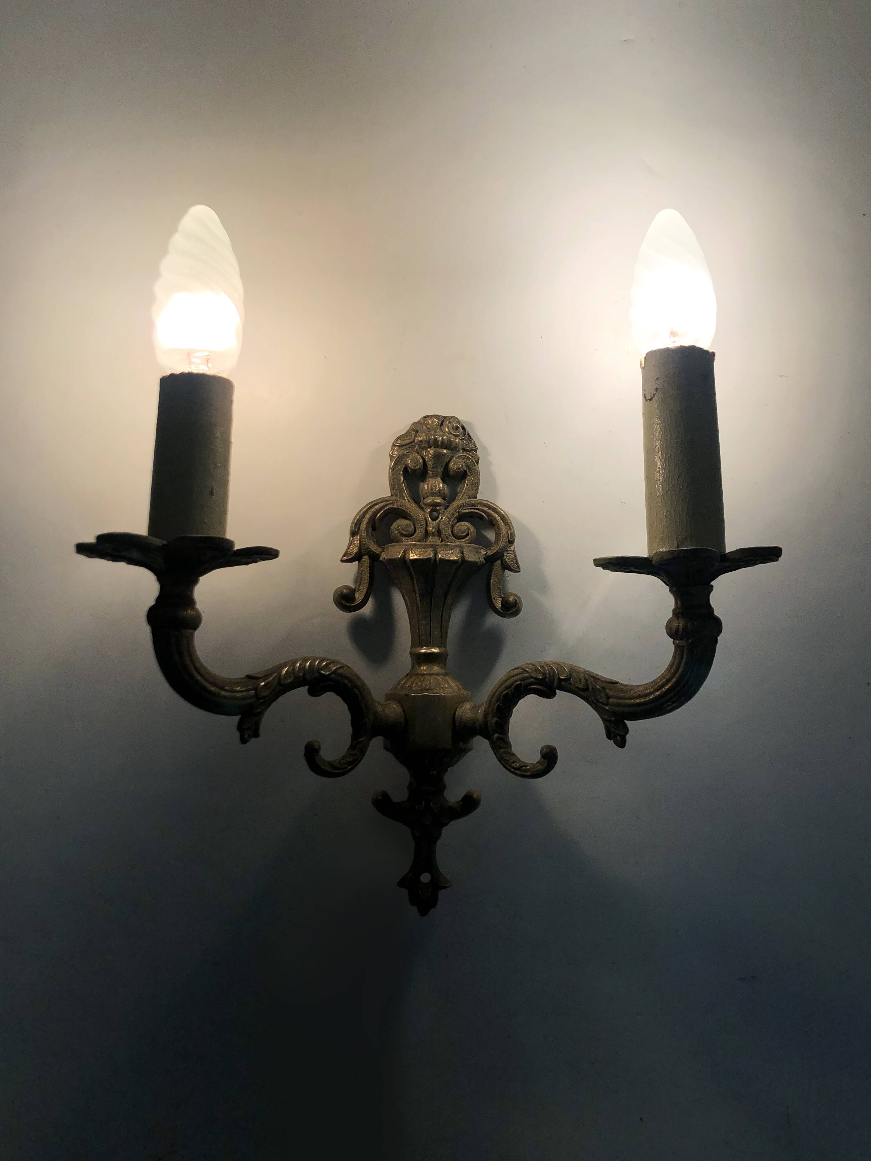 Pair of two-armed fire pot wall lights in gilded bronze.