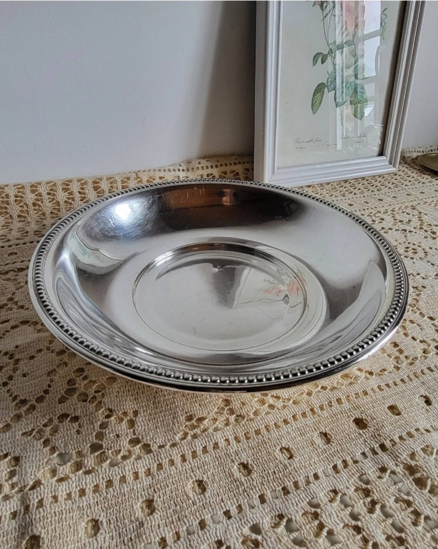 Shallow round metal plate with pearl row decoration.