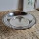 Shallow round metal plate with pearl row decoration.