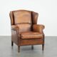 Fauteuil à oreilles en cuir de mouton charmant avec des couleurs chaudes.