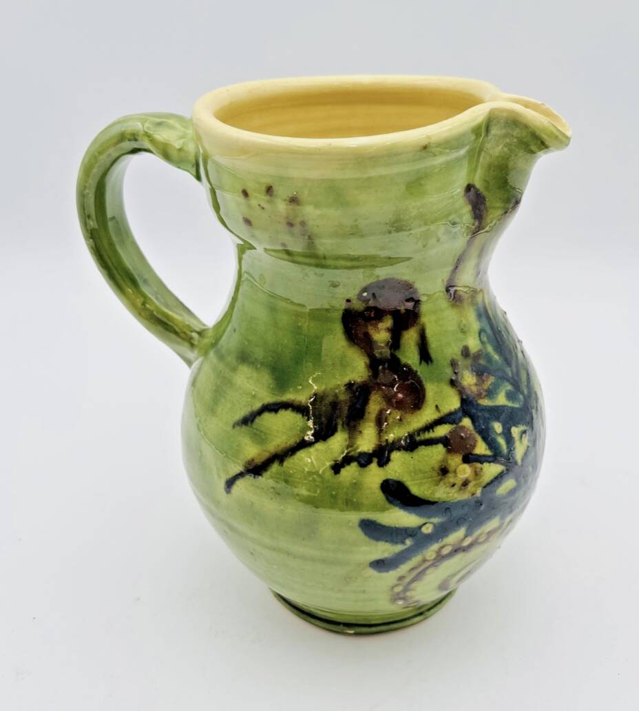 Green stoneware pitcher with flower and brown bird decoration