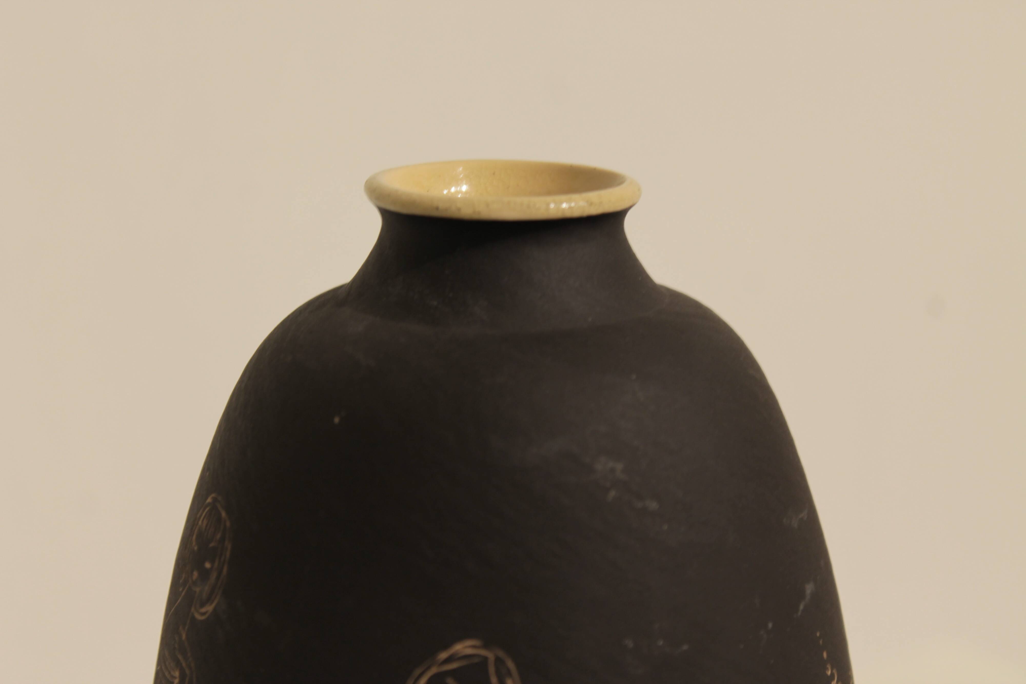 Ceramic vase decorated with women and a tree.