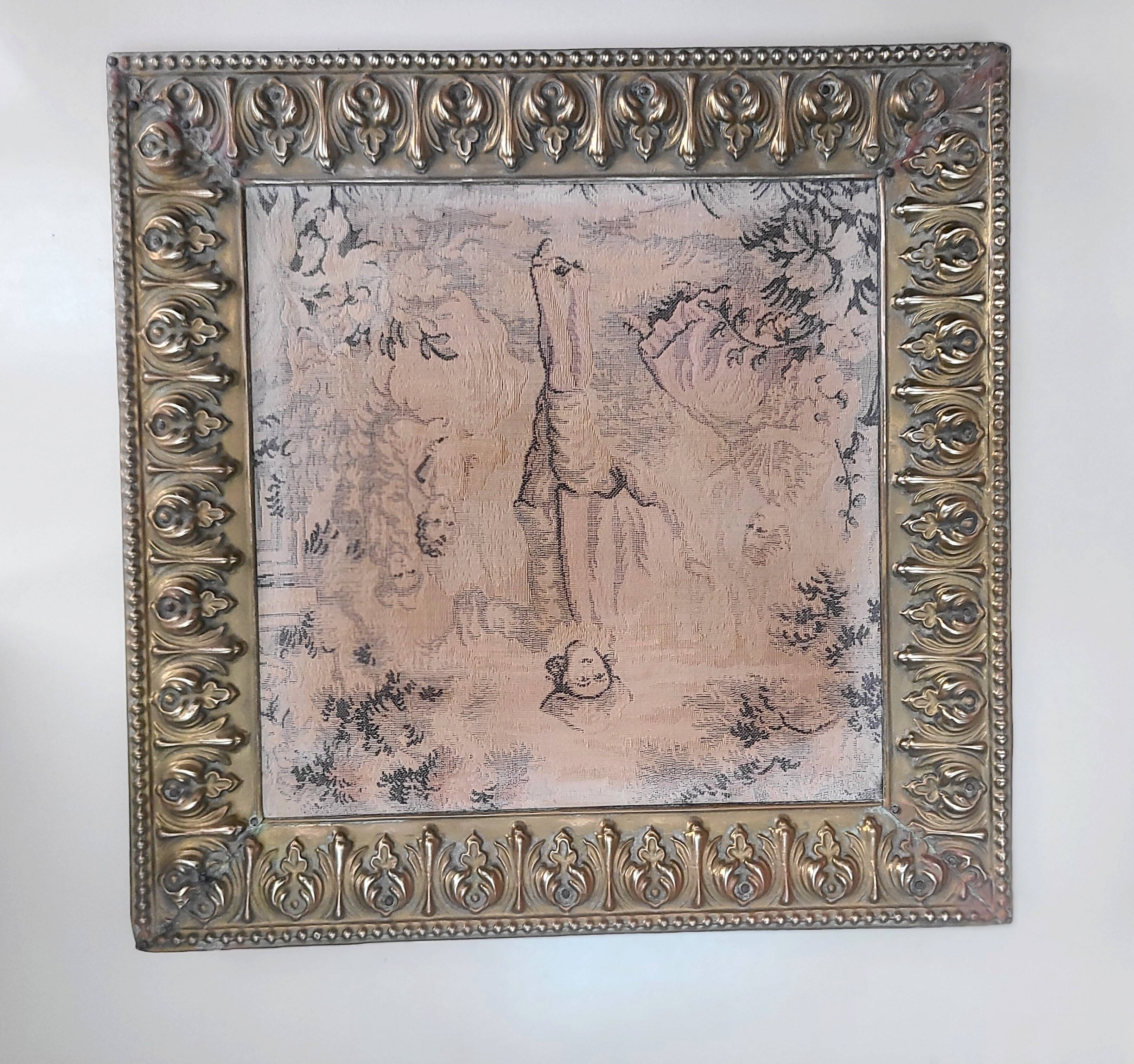 Antique tapestries framed in repoussé brass.