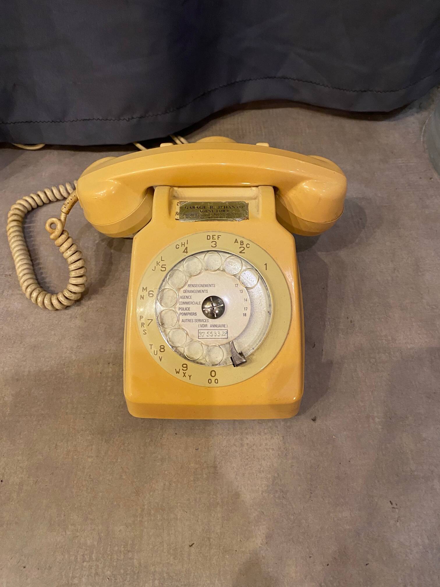 Old dial telephone from the 80s temat quimper bakelite yellow and beige