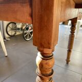 Oval wooden table with drop-leaf edges.