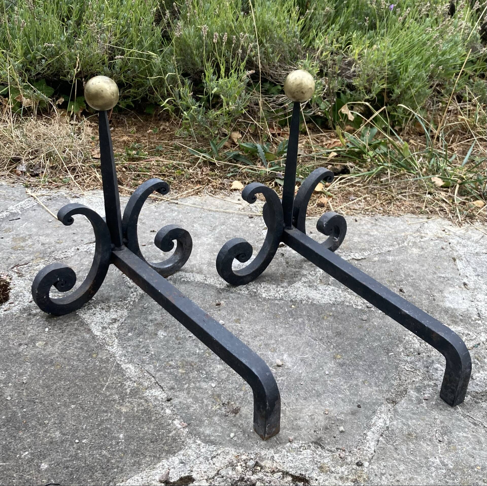 Massive wrought iron chenets from the 19th century topped with brass balls.