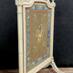 Front of Louis XVI fireplace in laqué wood and fabric has floral decorations