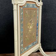 Front of Louis XVI fireplace in laqué wood and fabric has floral decorations