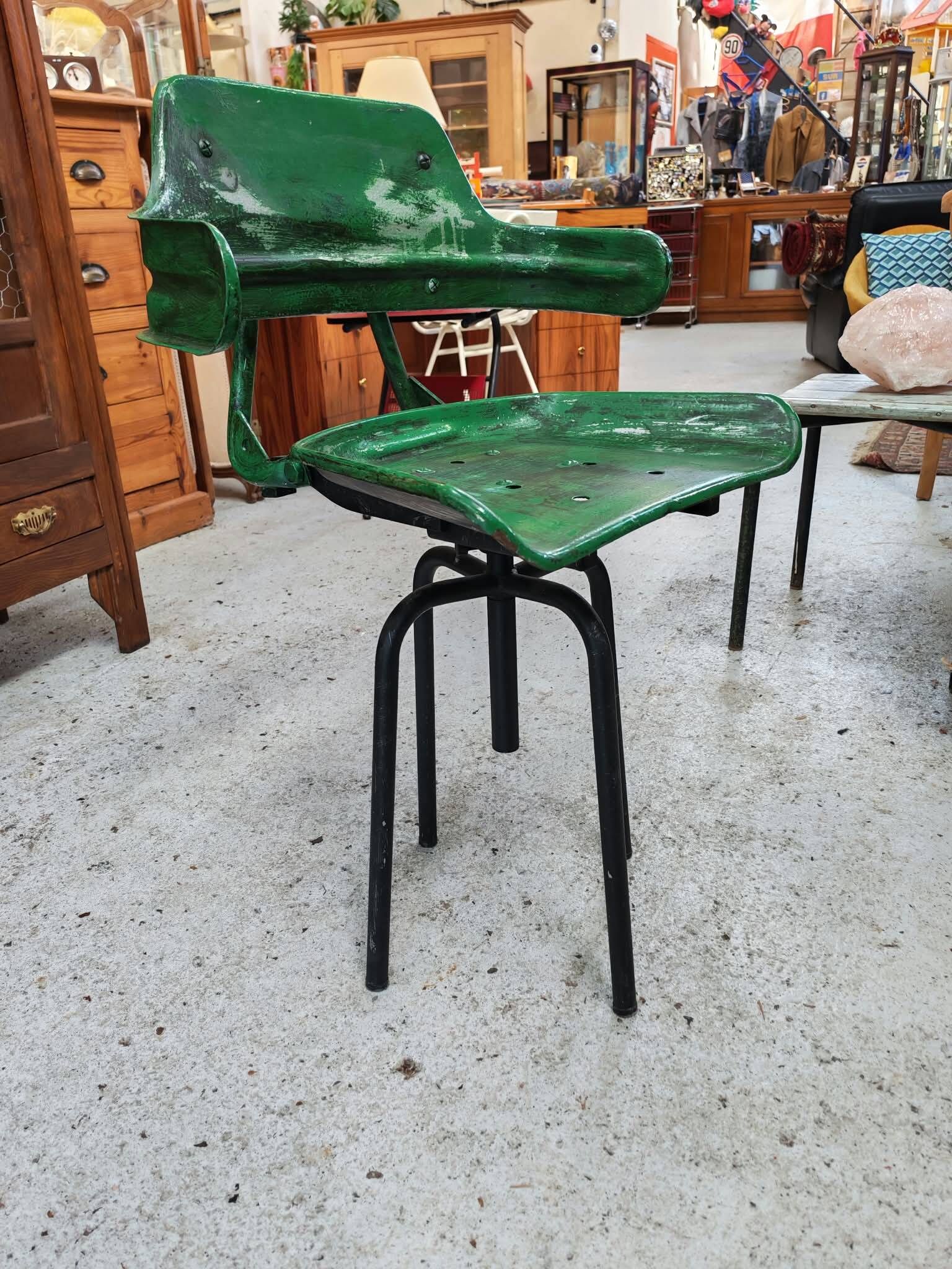 Vintage swivel workshop chair in green pressed sheet metal with a folding backrest.