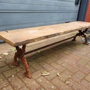 French country-style cast iron garden bench with old barn wood plank.