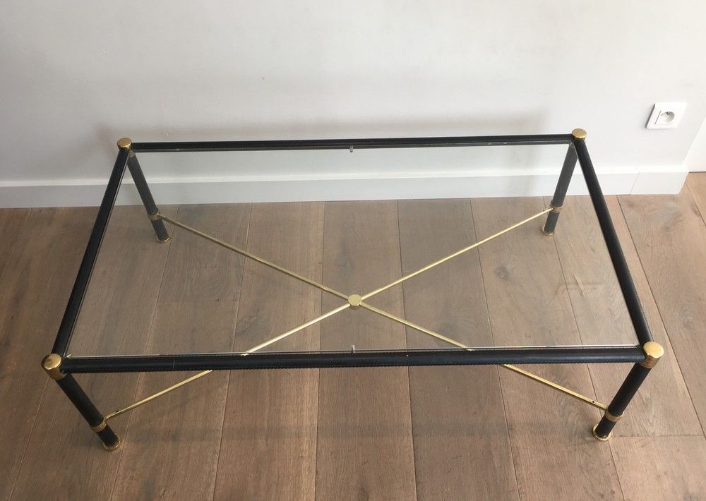 Brass coffee table upholstered in black leather. In the style of Jacques Adnet.