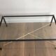 Brass coffee table upholstered in black leather. In the style of Jacques Adnet.