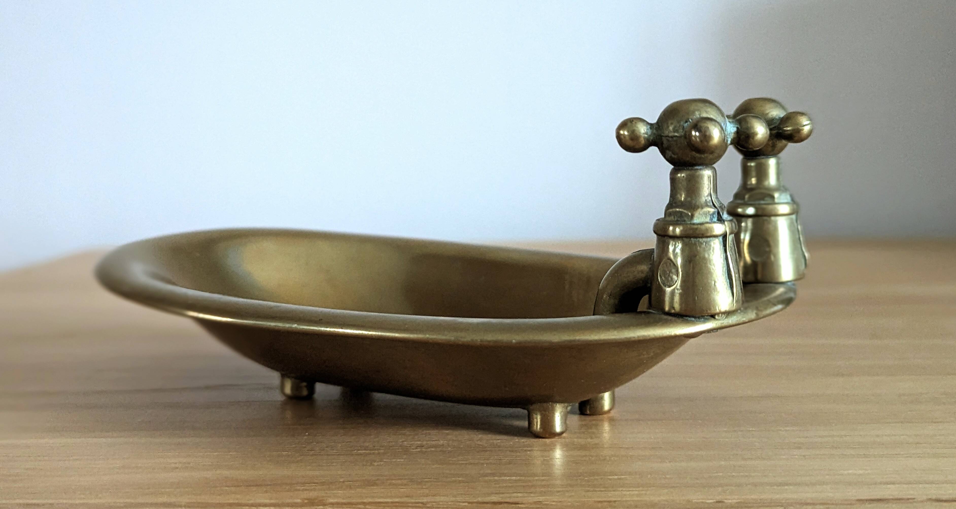 Old soap dish in the shape of a brass bathtub