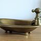 Old soap dish in the shape of a brass bathtub