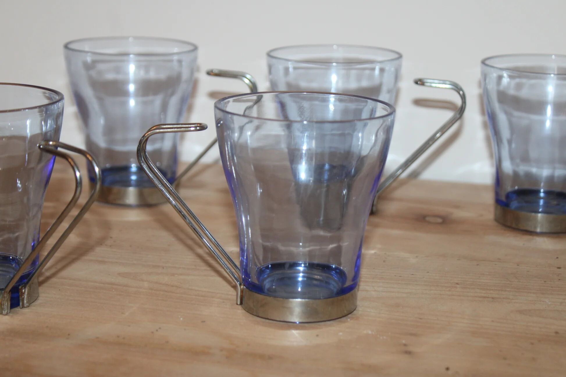 Set of 5 vintage blue-tinted glass cups with metal holders.