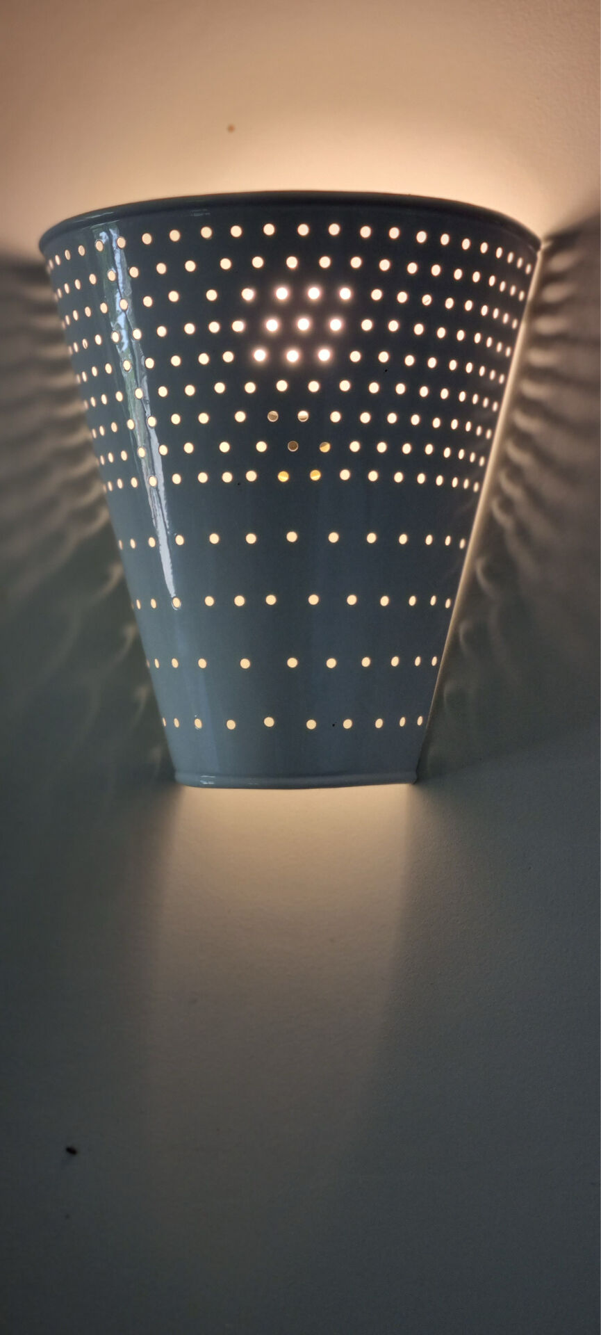White lacquered perforated sheet metal applique in new condition.