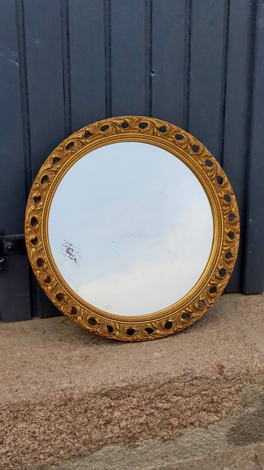 Round neoclassical style mirror in wood and gilded stucco from the 1950s