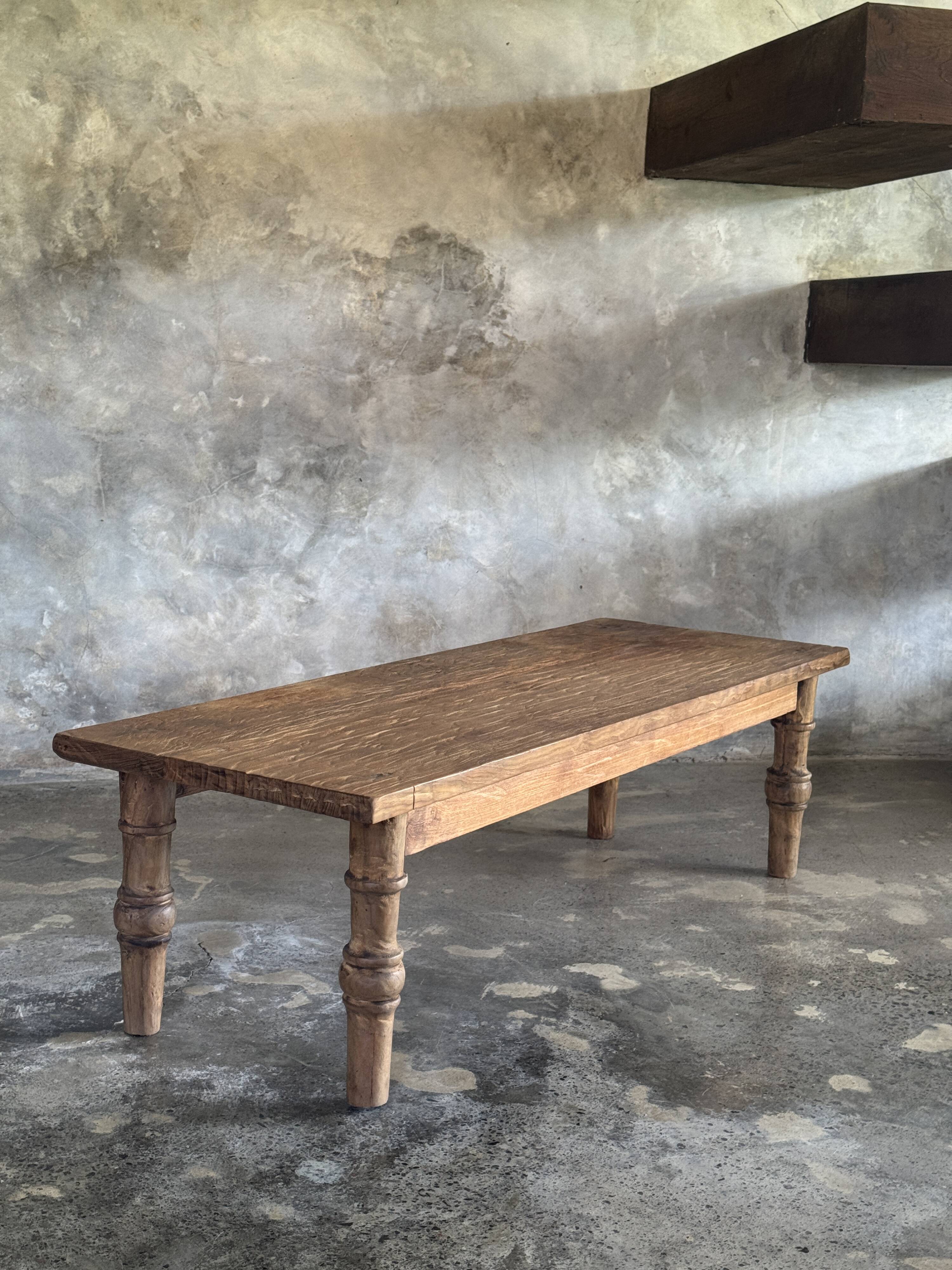 Brown Indonesian teak coffee table, with a border and cylindrical legs H40 L103.