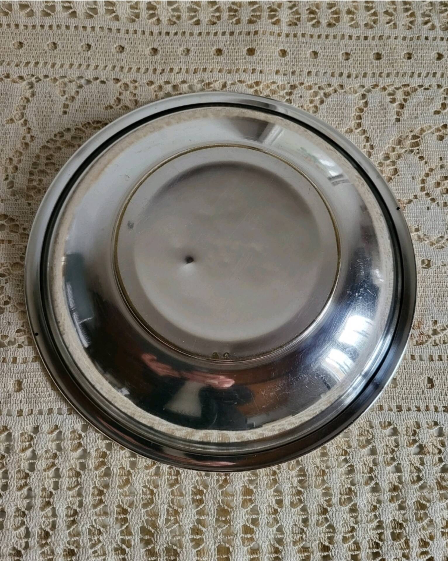 Shallow round metal plate with pearl row decoration.