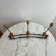 Wall-mounted coat rack in wrought iron with turned wooden knobs.