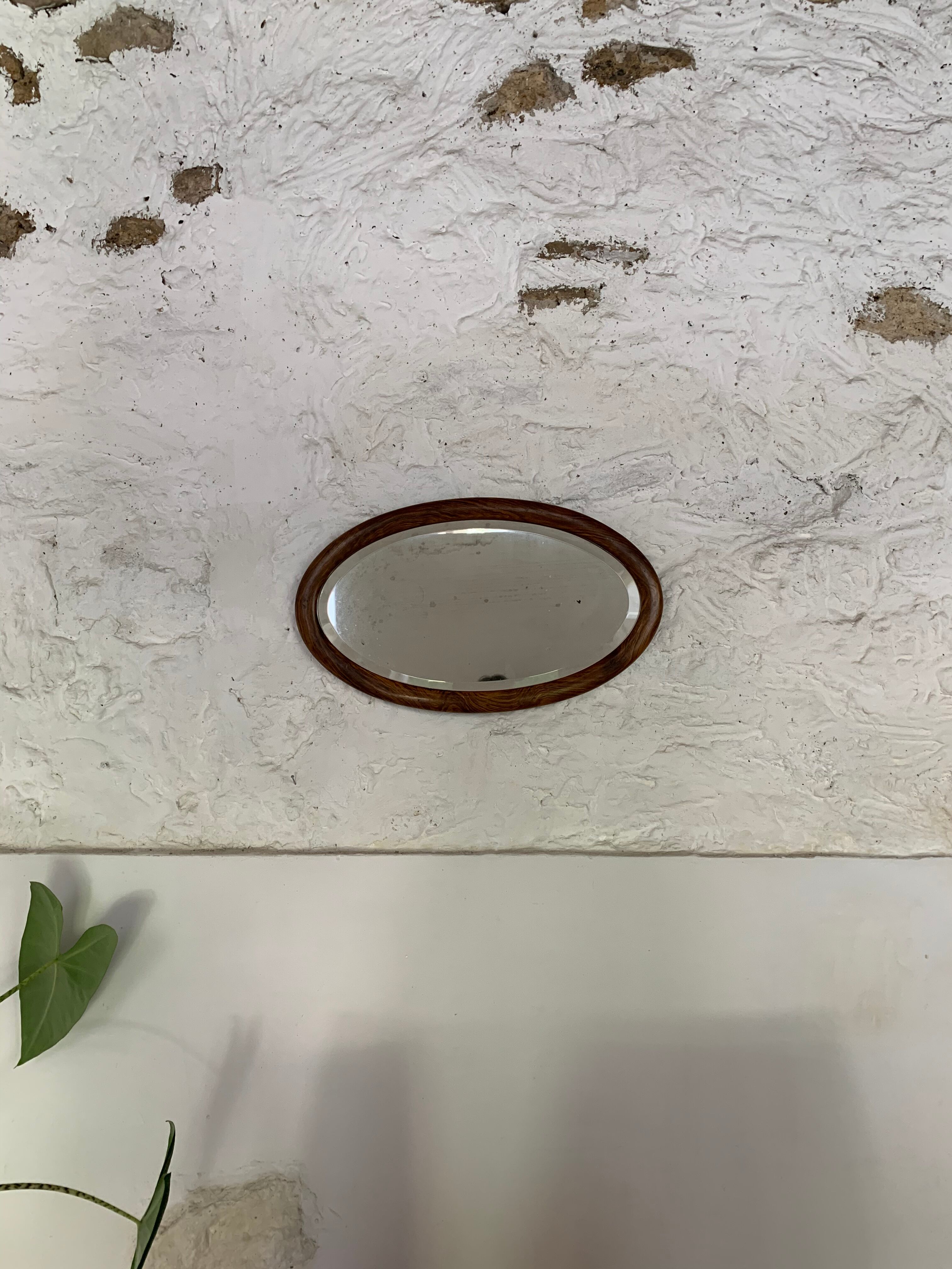 Oval wooden and stucco wall mirror