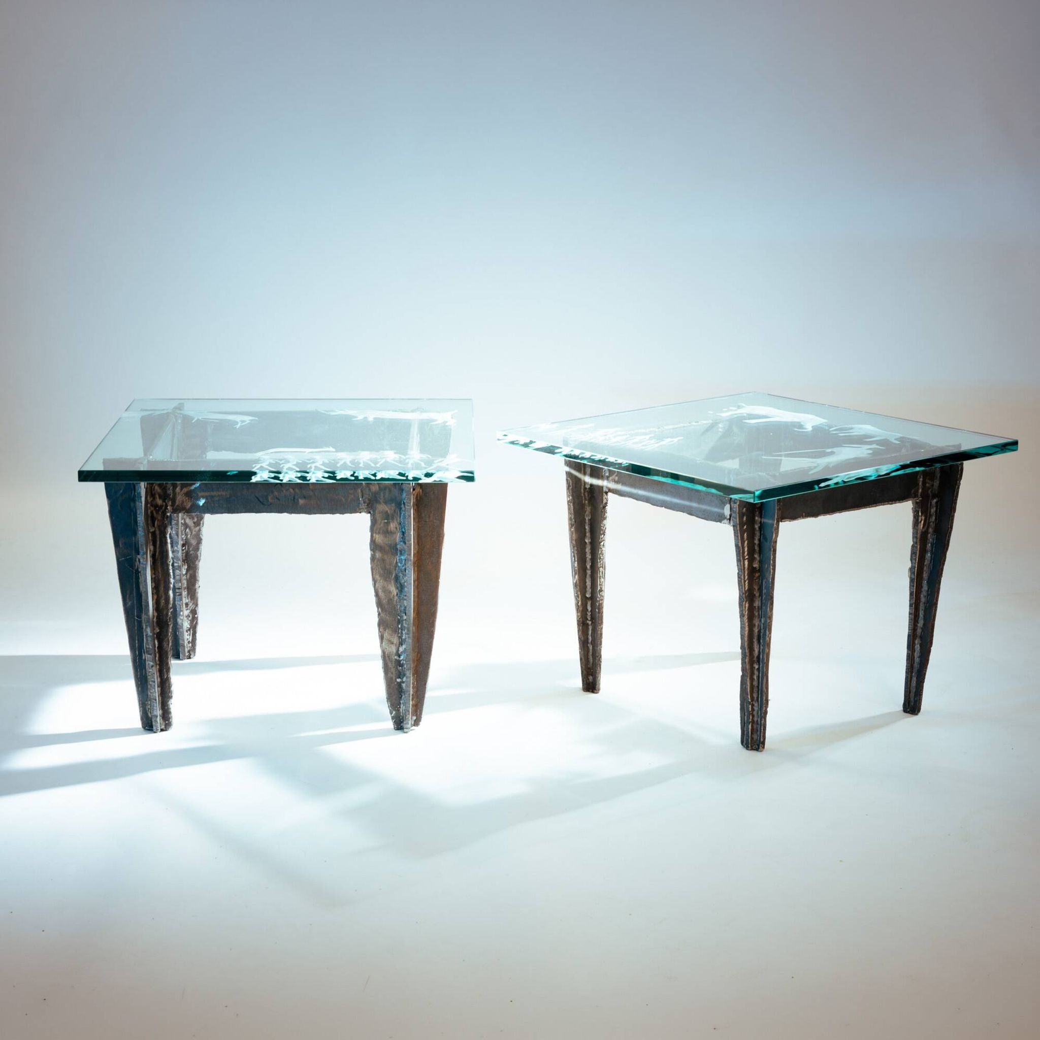 2 brutalist steel side tables with primitive  scene motifs etched glass