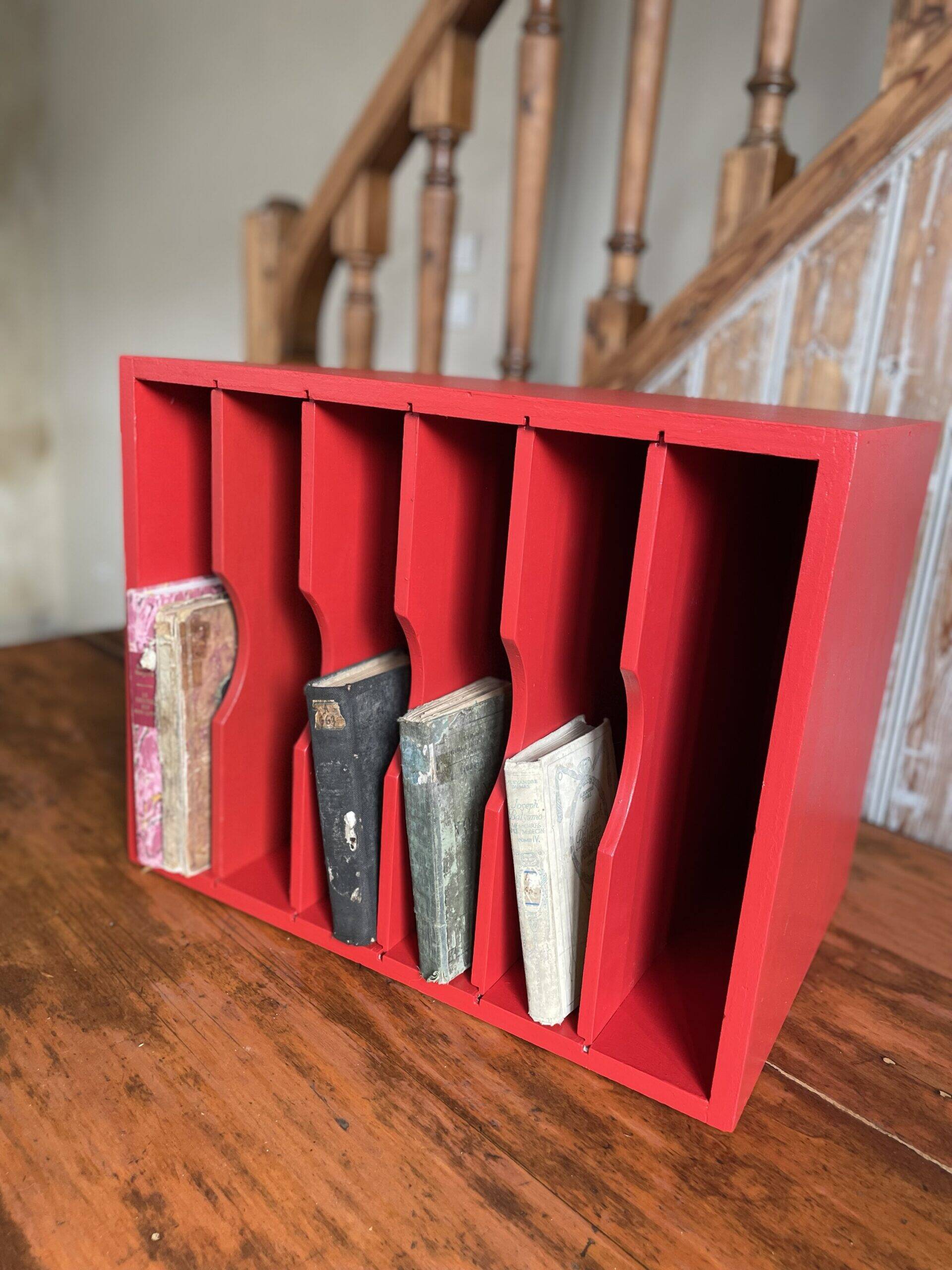 Vintage wooden magazine rack in red.