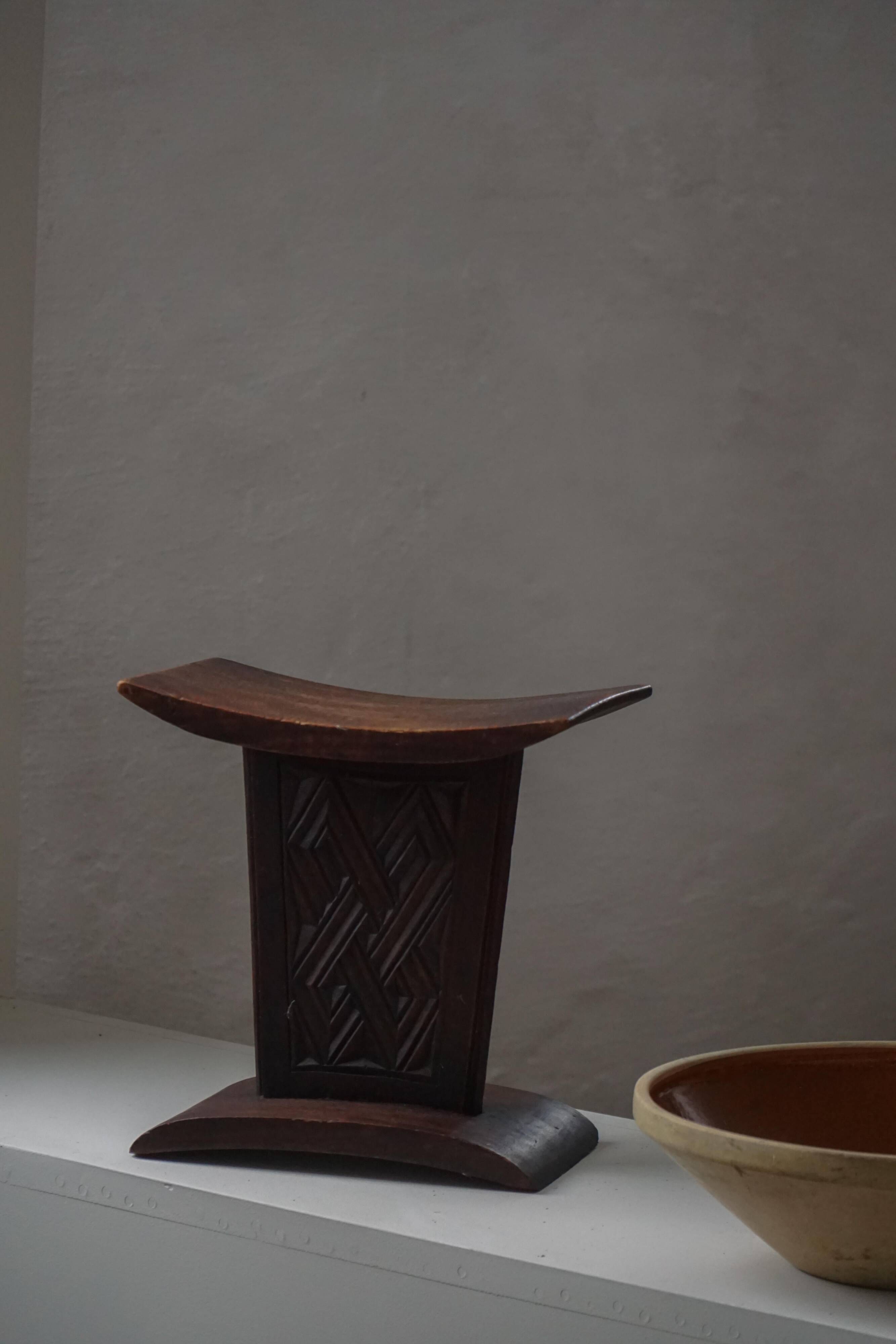 Sculptural African stool in hardwood, curved seat and architectural base, 1970s.