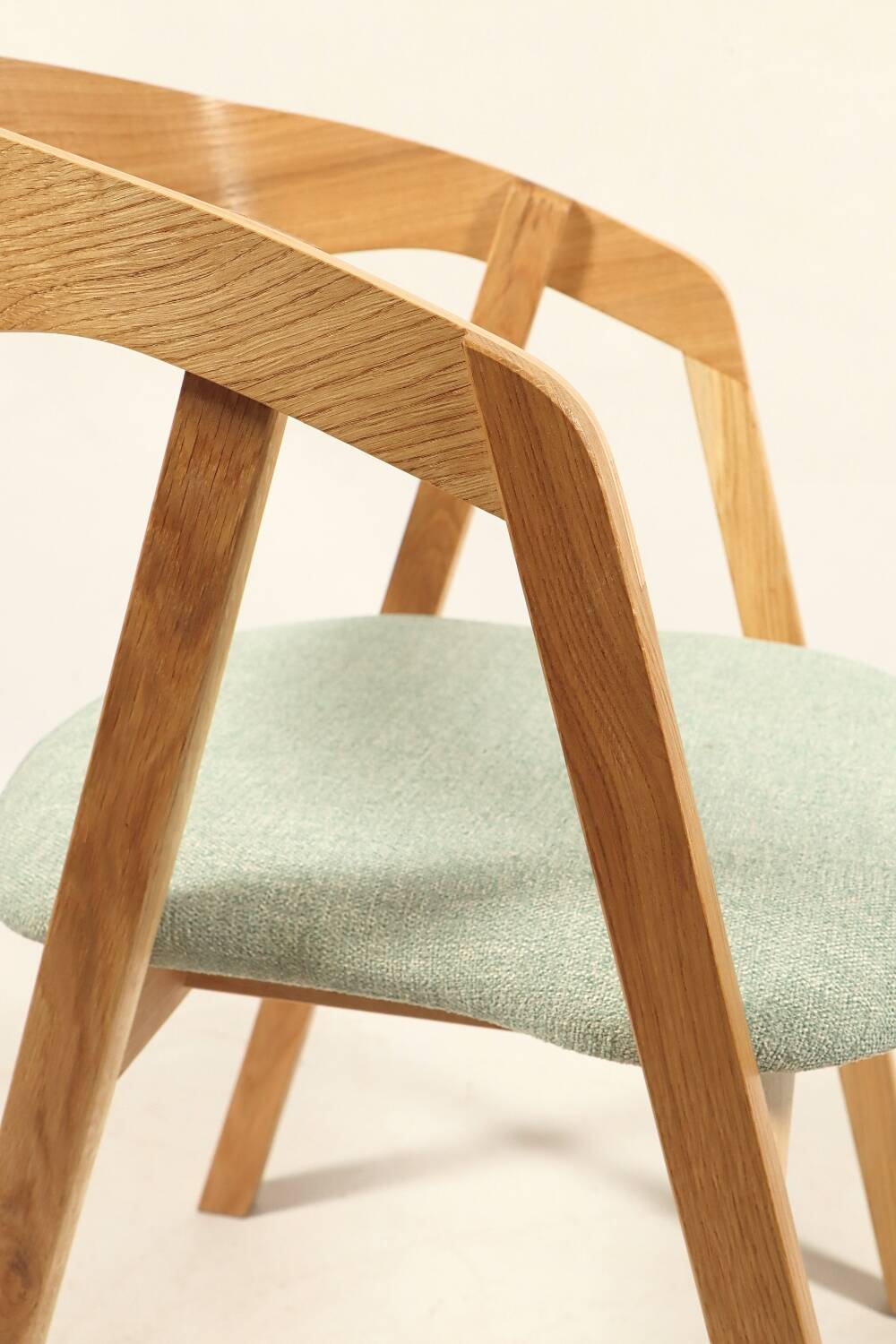 Vintage dining chair in light oak with natural linen pastel green fabric.