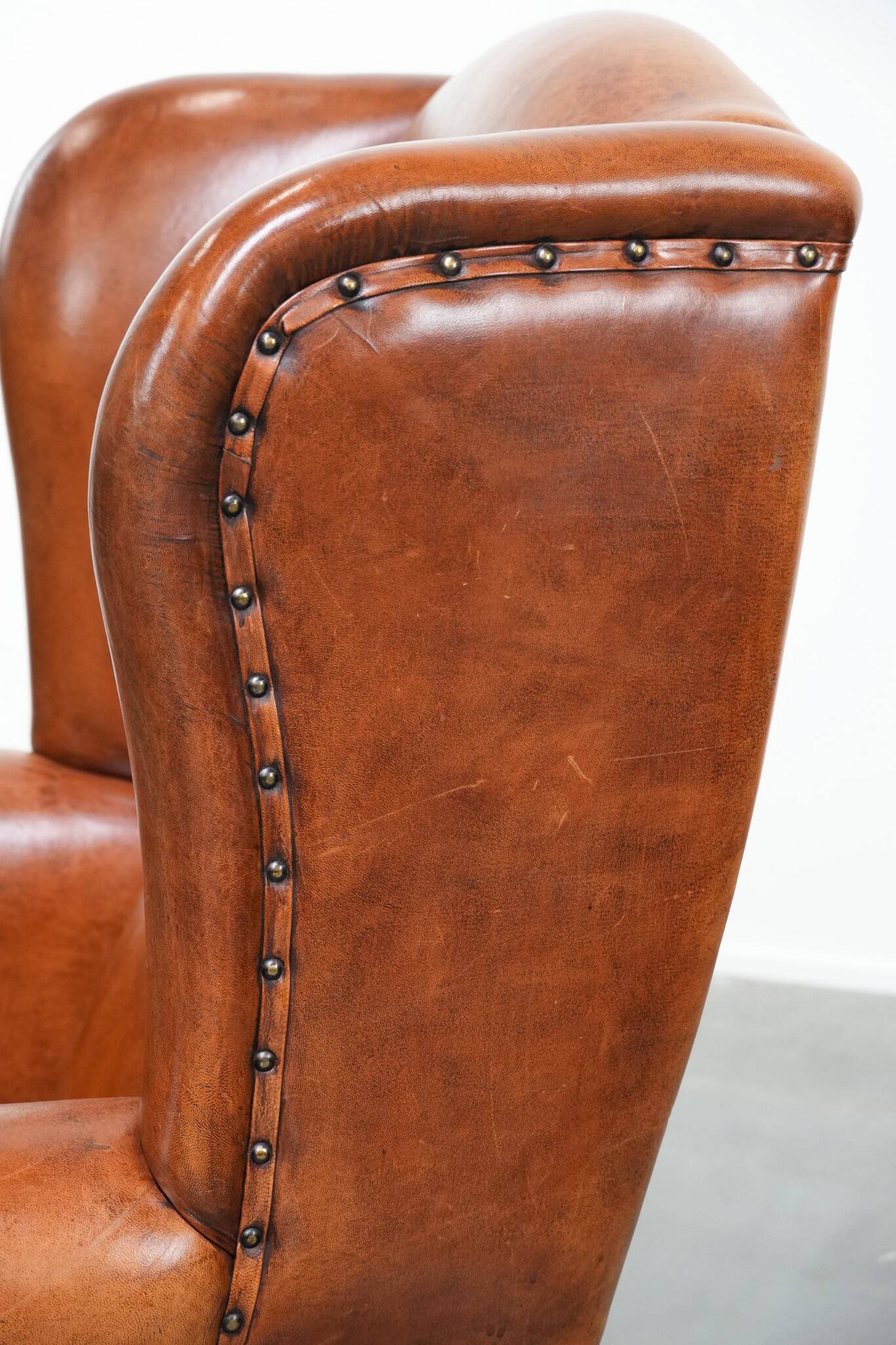 Wingback chair made of sheep leather with black piping in good condition