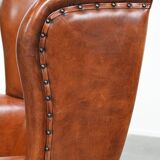 Wingback chair made of sheep leather with black piping in good condition