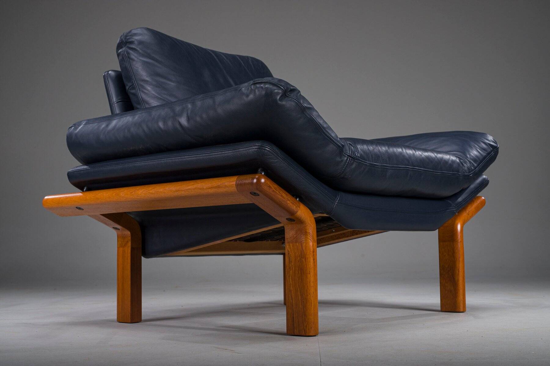 Danish teak and navy blue leather lounge chair from Komfort, 1970s