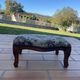 Antique wooden footstool with hand-carved details and floral upholstery –