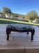 Antique wooden footstool with hand-carved details and floral upholstery –
