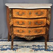 Louis XV style commode with rosewood veneer, gilded bronze mounts, and marble top.