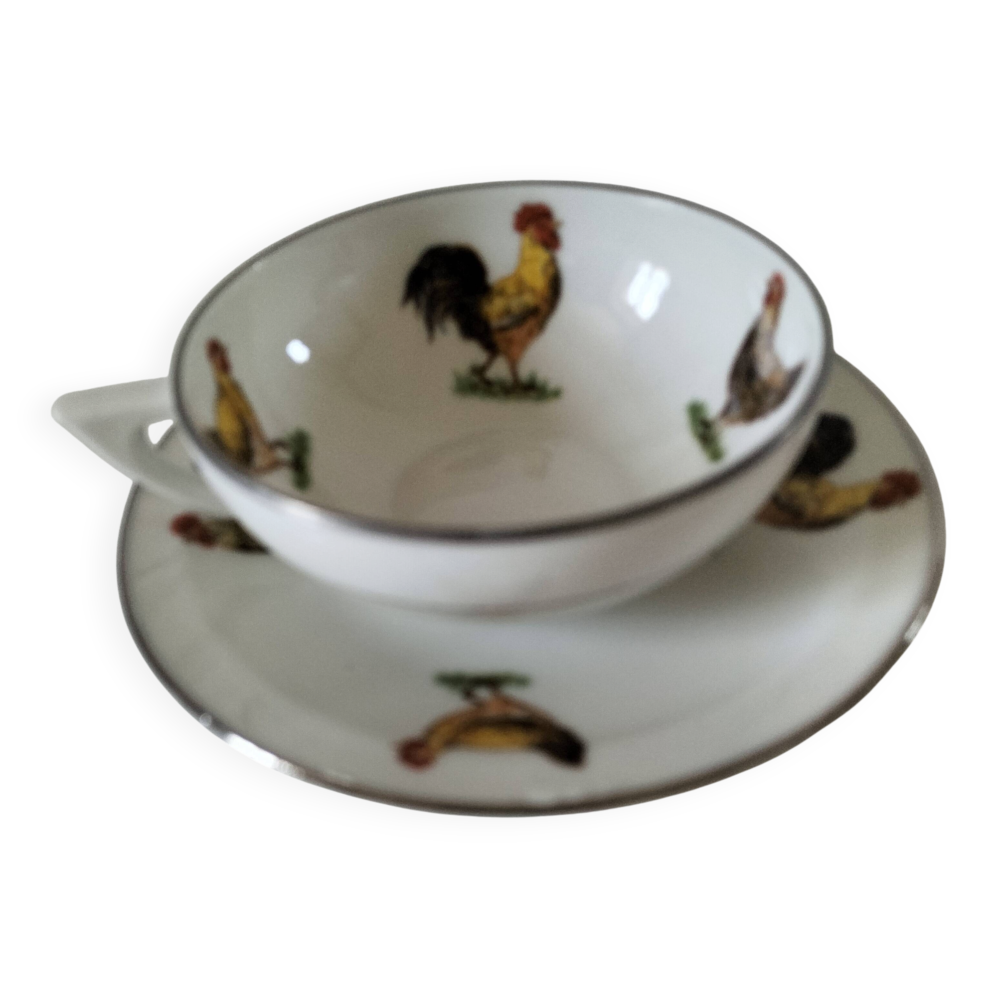 Cup and saucer in porcelain decorated with roosters and hens.