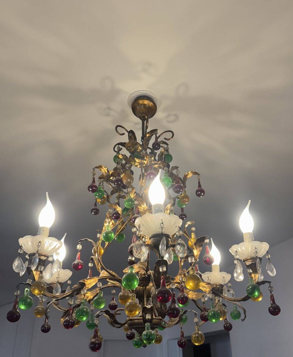 Lustrous chandelier with two wall lights decorated with foliage and pendants.