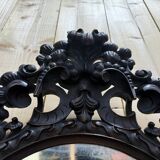 Oval mirror in carved wood with dragon heads.