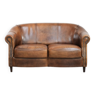 Canapé club 2 places vintage, robuste et au caractère affirmé, en cuir de peau de mouton.