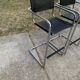Set of 2 mid-century tubular black bar stools in faux leather and chrome metal.